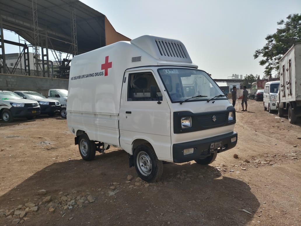 White supply van with red cross livery reading “We deliver life saving drugs”