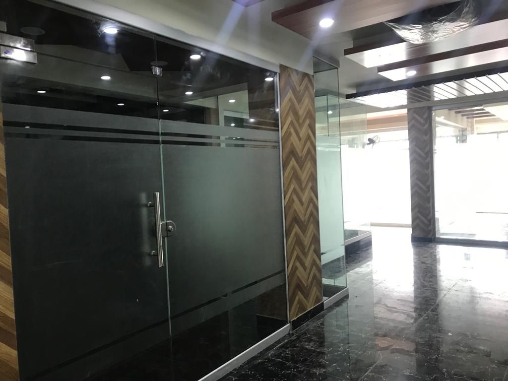 Head office corridor with glass offices and polished stone flooring