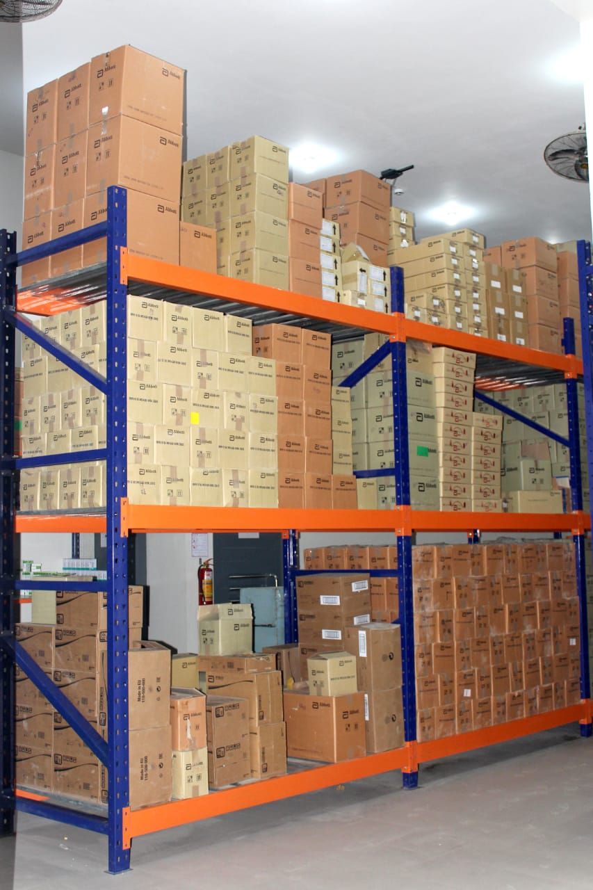Tall blue and orange pallet racking loaded with pharmaceutical cartons